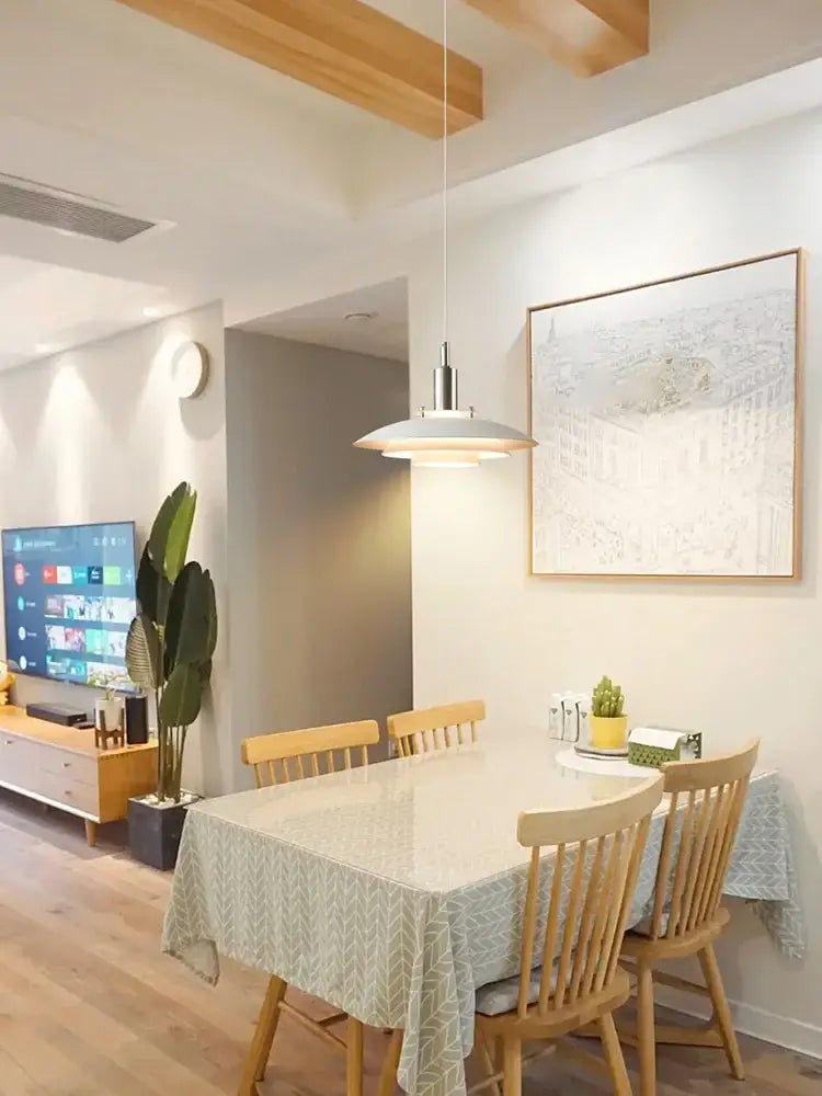 A modern tiered colorful metal hanging light with sleek metallic finish suspends as a decorbites Danish designer lamp