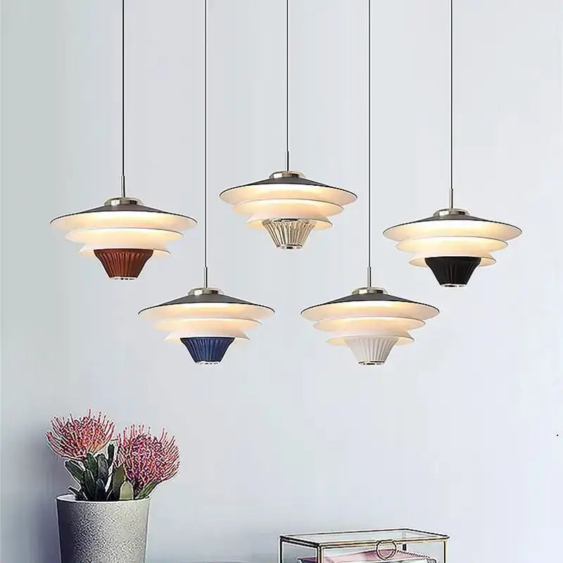 Modern tiered pendant lights with cream wind milk glass shades and metallic accents in brown blue black white and silver