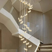 A modern chandelier with translucent butterfly-shaped pendant lights suspended by thin cords for decorbites butterfly staircase