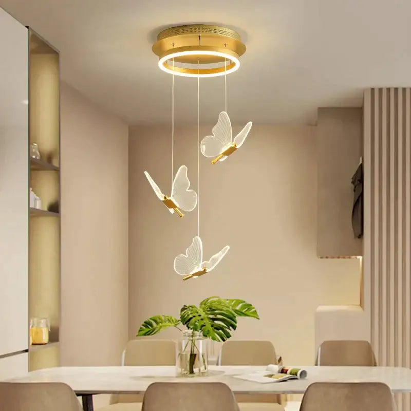 Gold-toned circular pendant lights with three translucent white butterfly staircase pendant shades for modern stairwell decorbites decor