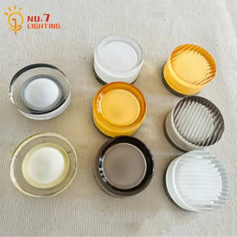 A collection of colorful translucent glass light diffuser caps in white yellow amber and brown for dimple potato chip wall lamp