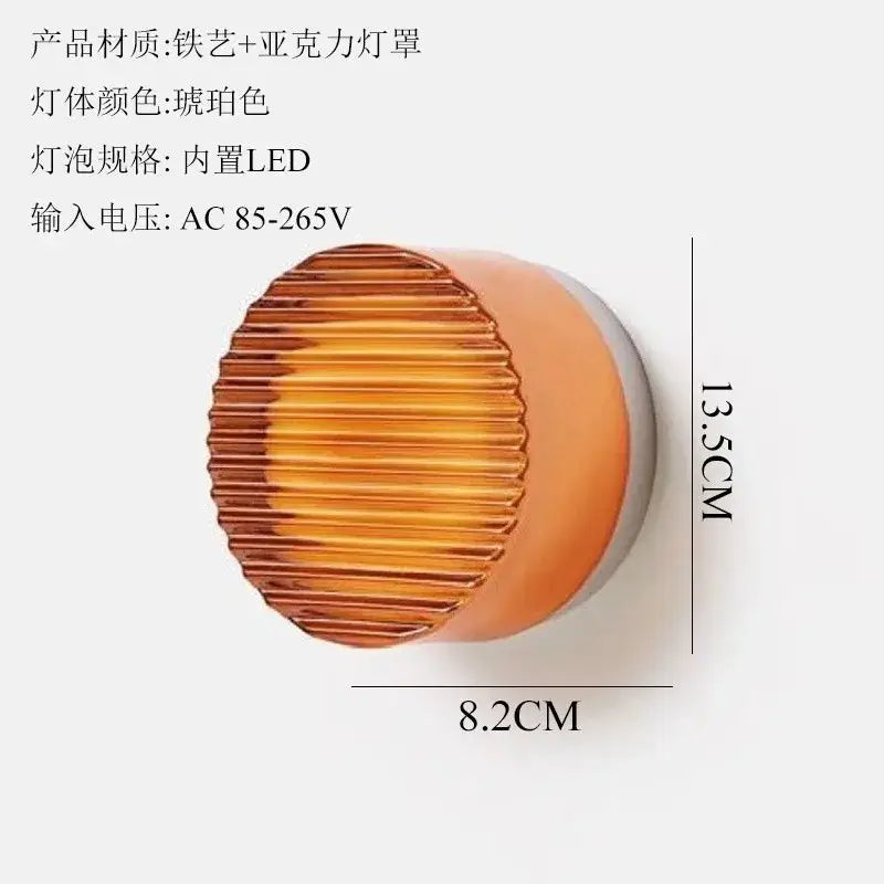 A sleek amber dimple potato chip wall lamp with ribbed acrylic shade iron base and integrated led bulb for bedroom use