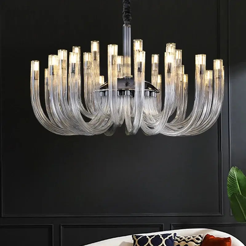 A modern transparent glass chandelier led hanging light with clear curved glass arms and chrome fixture for dining room