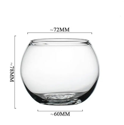 Clear glass fishbowl with rounded shape featured alongside a modern transparent glass coffee mug for kitchen and dining room