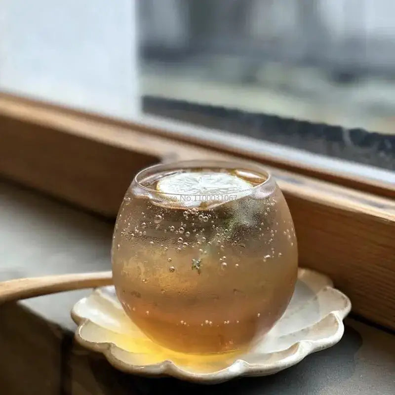 Modern transparent glass coffee mug filled with golden carbonated beverage and lemon slice for kitchen use