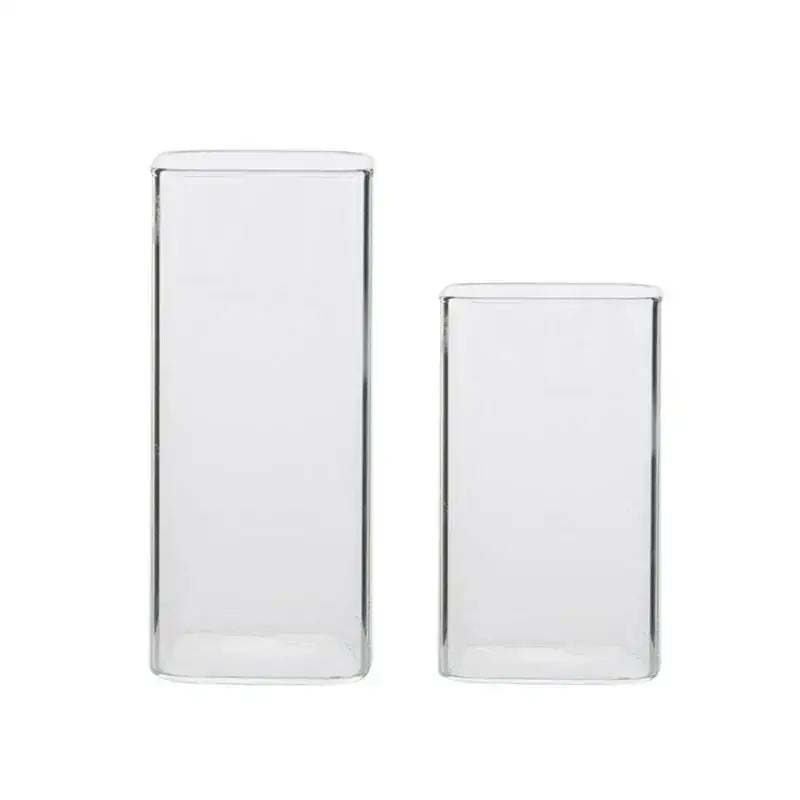 Two clear transparent glass square measuring cups in rectangular vases for kitchen and dining use