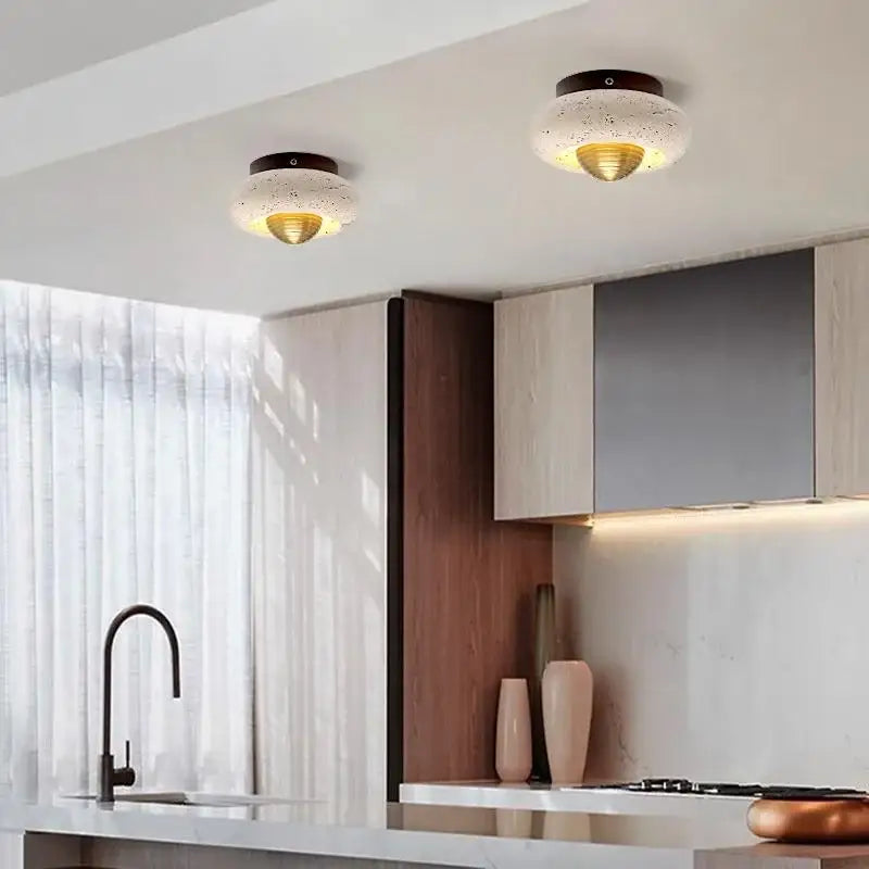 Two modern decorbites led ceiling lights with speckled white glass shades and gold interiors on dark bases for bedroom decor
