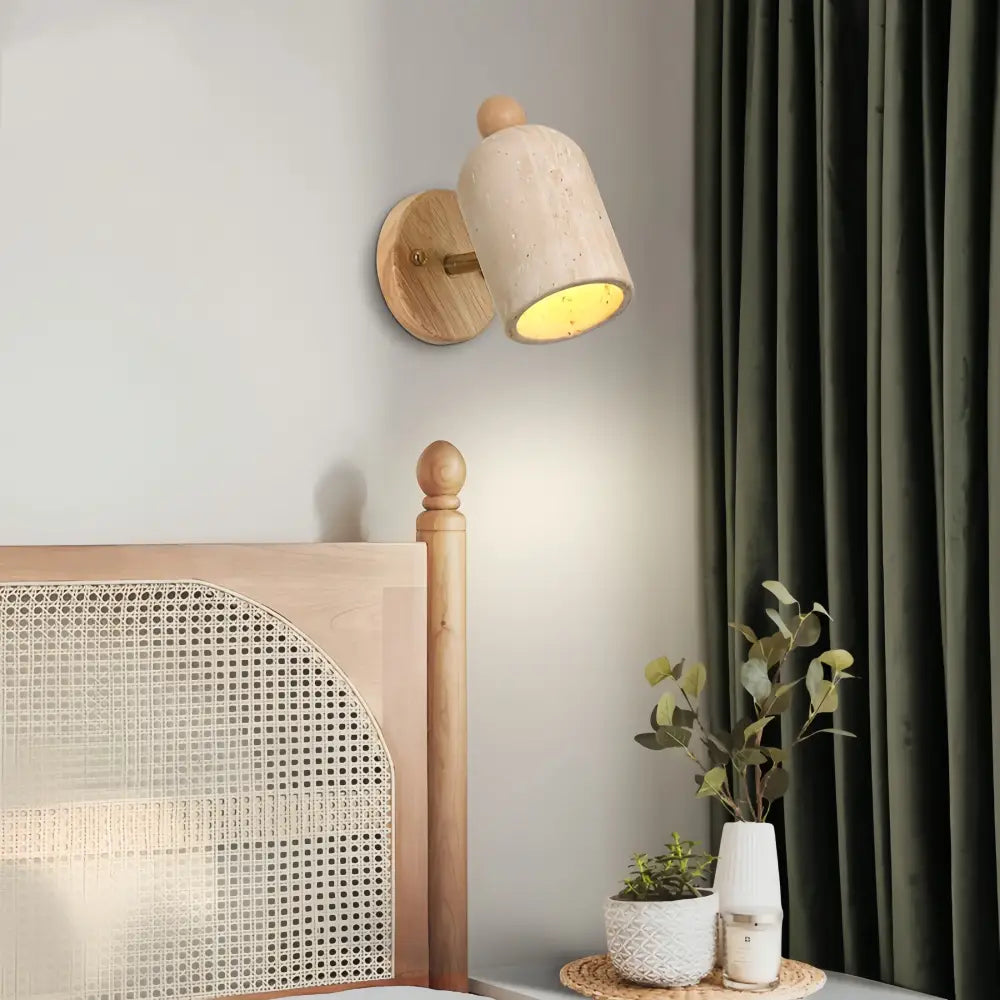 Minimalist wall light fixture with light beige concrete shade and natural wood base featuring a wooden knob and pull chain switch