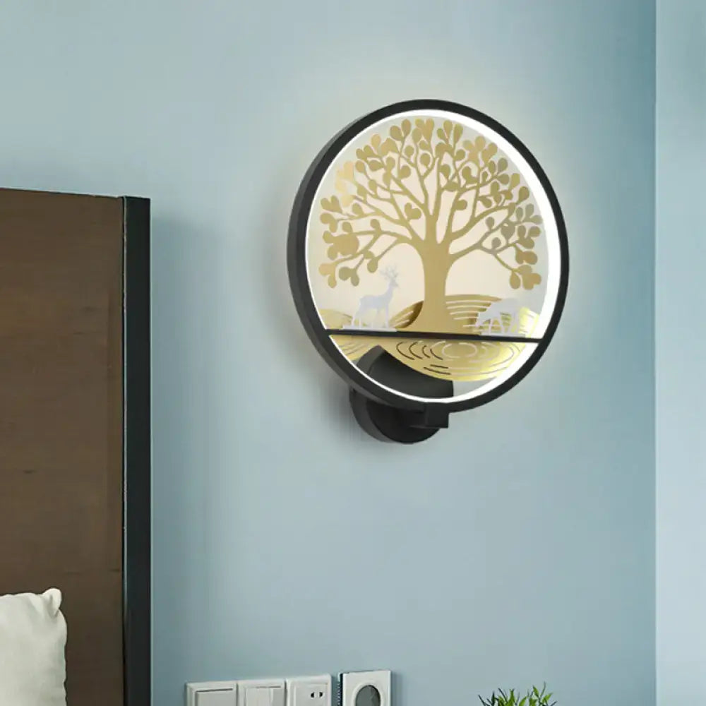 Modern wall lamp with a black frame and illuminated golden tree of life design featuring deer silhouettes for bedroom use