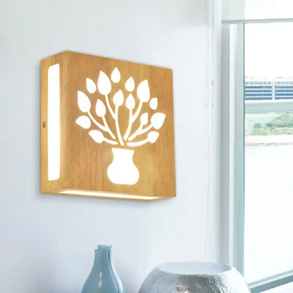 Square wooden wall light with carved tree-in-vase design in bamboo, emitting warm light, direct wired electric with max bulb wattage