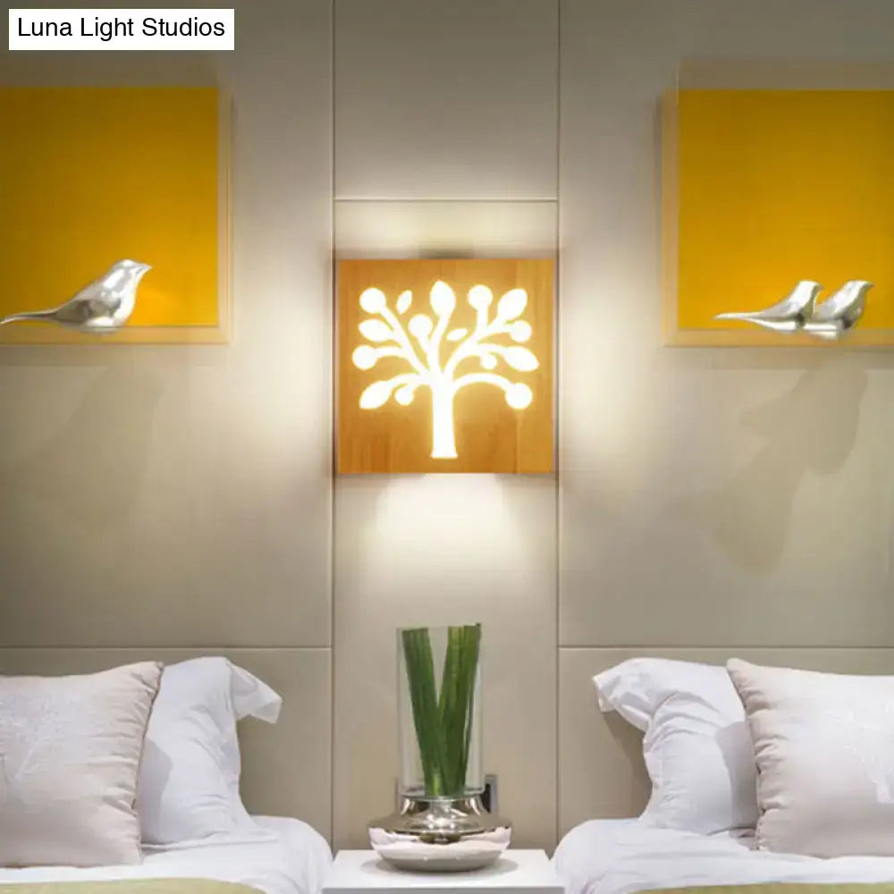 A warm illuminated wooden square flush mount wall sconce with a stylized tree design for corridor lighting