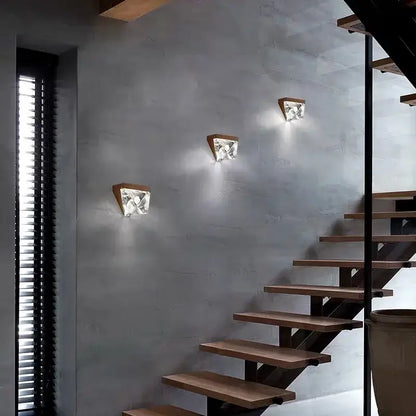 Three modern wall sconces with triangular bronze wooden bases and faceted crystal shades for living room decorbites crystal wall