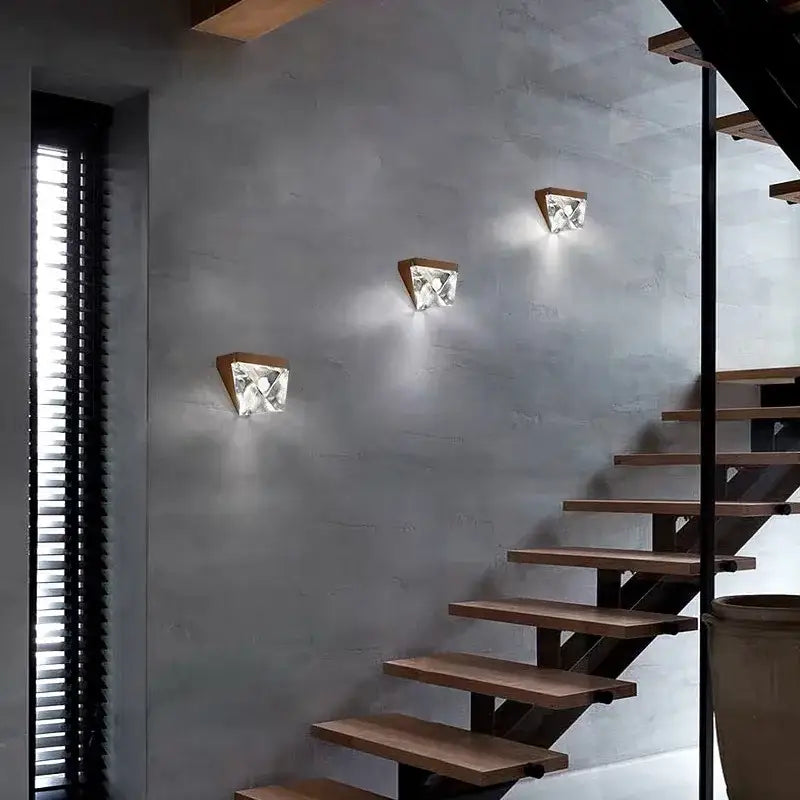 Three modern wall sconces with triangular bronze wooden bases and faceted crystal shades for living room decorbites crystal wall