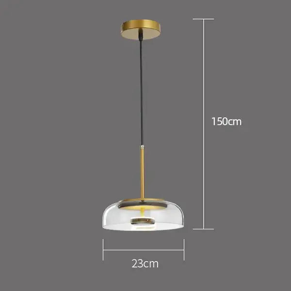 A modern glass pendant light with gold metal frame and clear shade hanging by black cord for dining room use