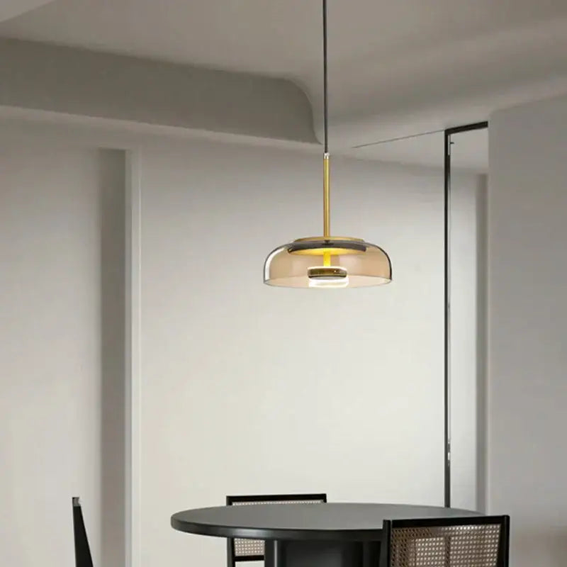 Modern tricolor glass pendant light with sleek gold metal frame and amber shade for dining room use