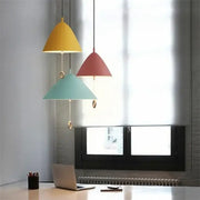 Three modern cone-shaped decorbites designer pendant lights in yellow red and teal with metallic hardware for dining room use
