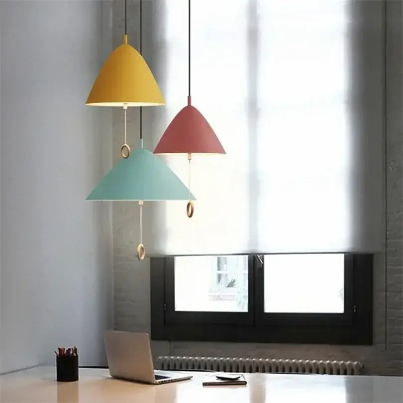 Three modern cone-shaped decorbites designer pendant lights in yellow red and teal with metallic hardware for dining room use
