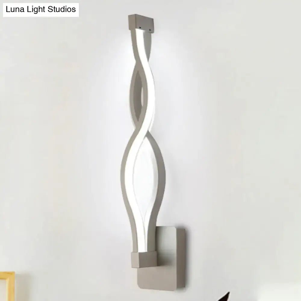 Modern silver-toned led wall sconce with twisted design and integrated lighting for bedroom wall decor