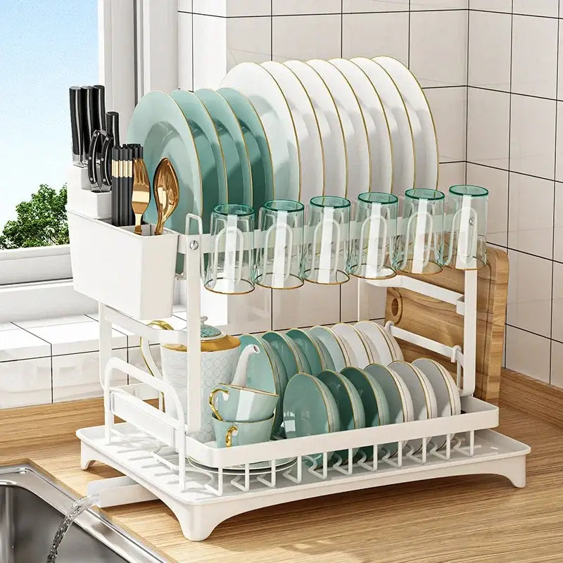 Modern two tier black metal dish drainer rack holding gold-trimmed plates and glasses with cutlery compartment