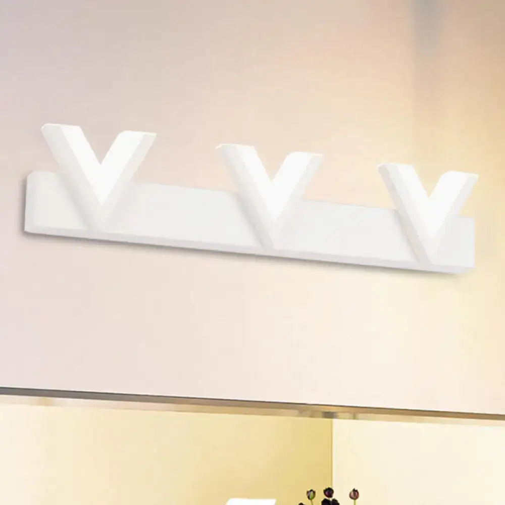 White modern wall-mounted coat rack with three v-shaped hooks paired with warm white led vanity light for bathroom