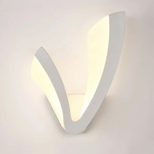 Modern v shaped white wall mounted light with sleek minimalist design providing warm white ambient bedroom lighting