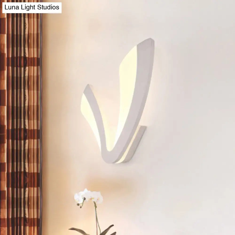 Modern white v shaped wall mounted light with a sleek curved design emitting warm ambient light for bedroom use
