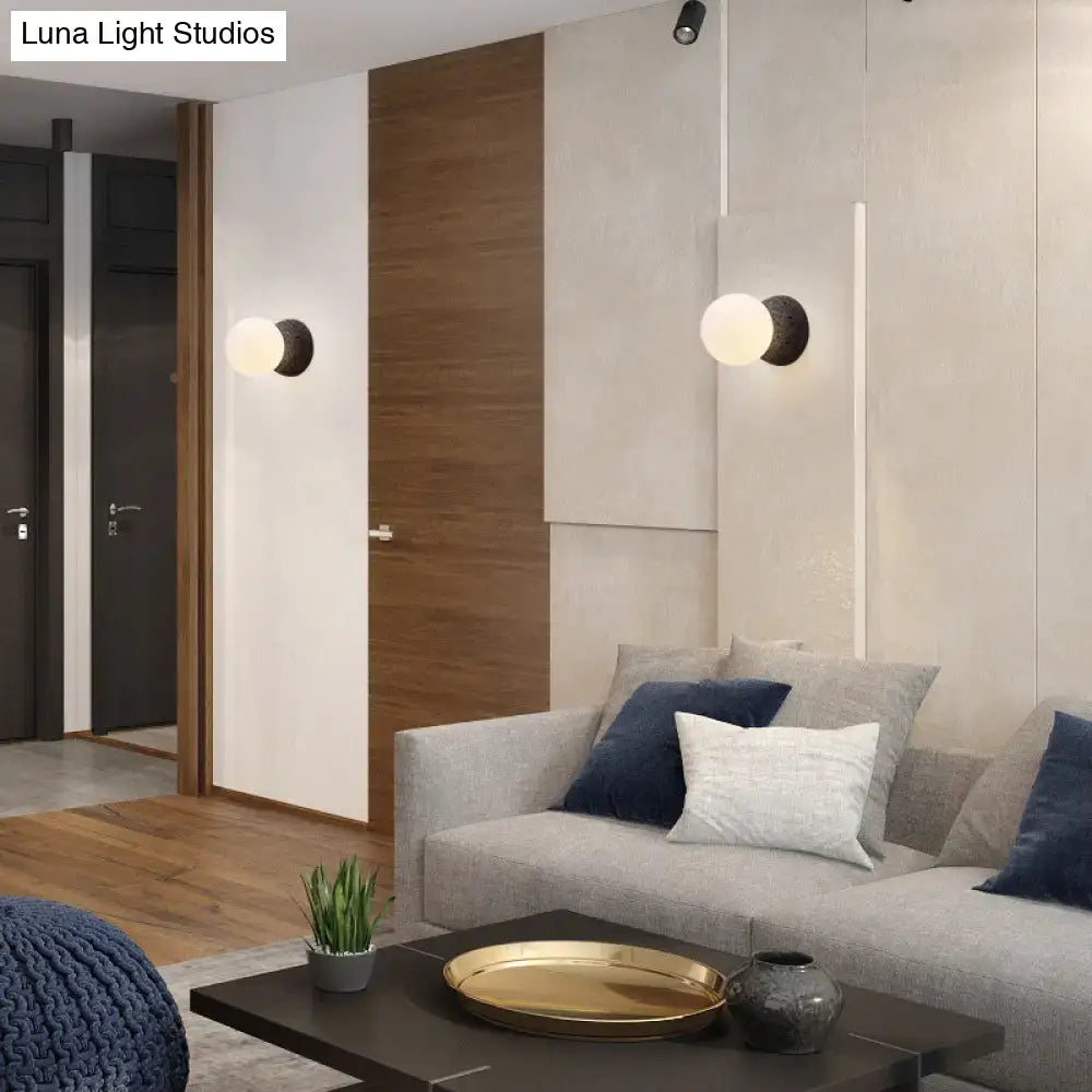 Modern volcanic stone wall lamp with matte black bulb base and frosted white glass globes for living room