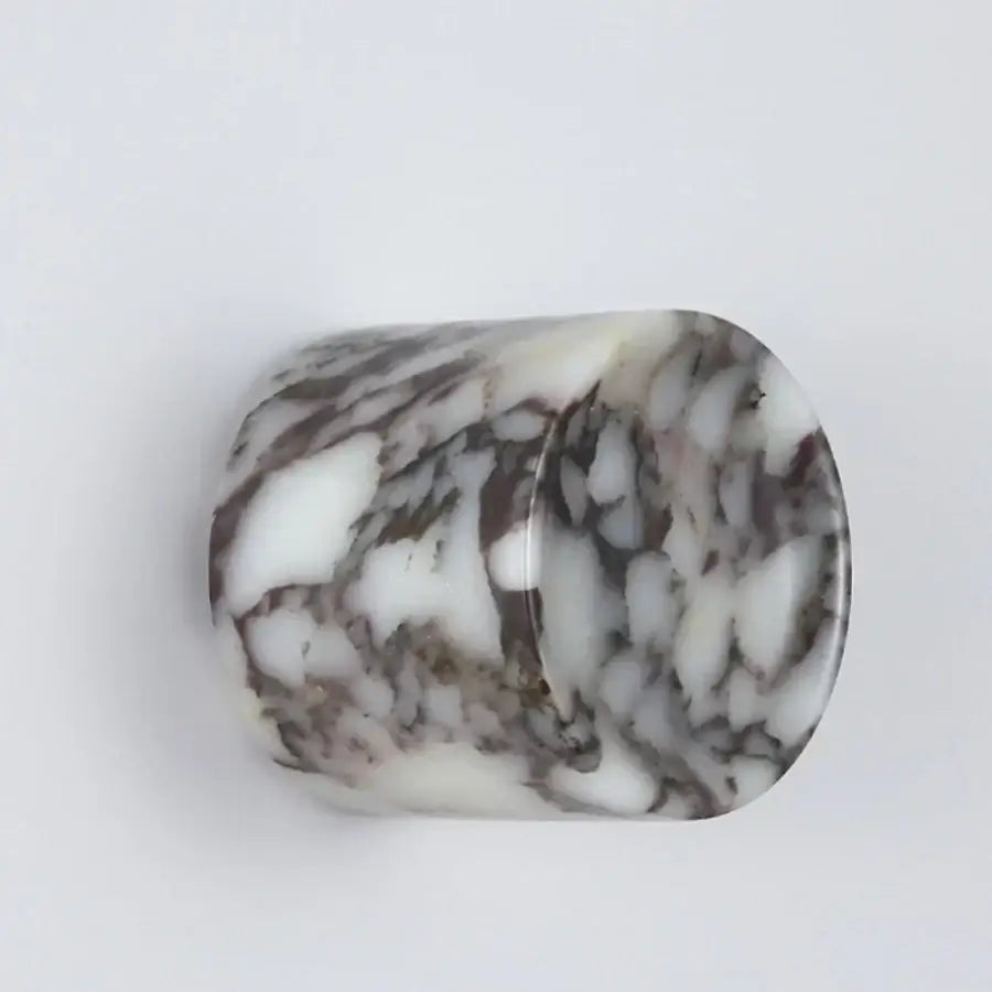 A translucent cylindrical led wall lamp with a swirling white and dark gray resin marble pattern for bedroom use