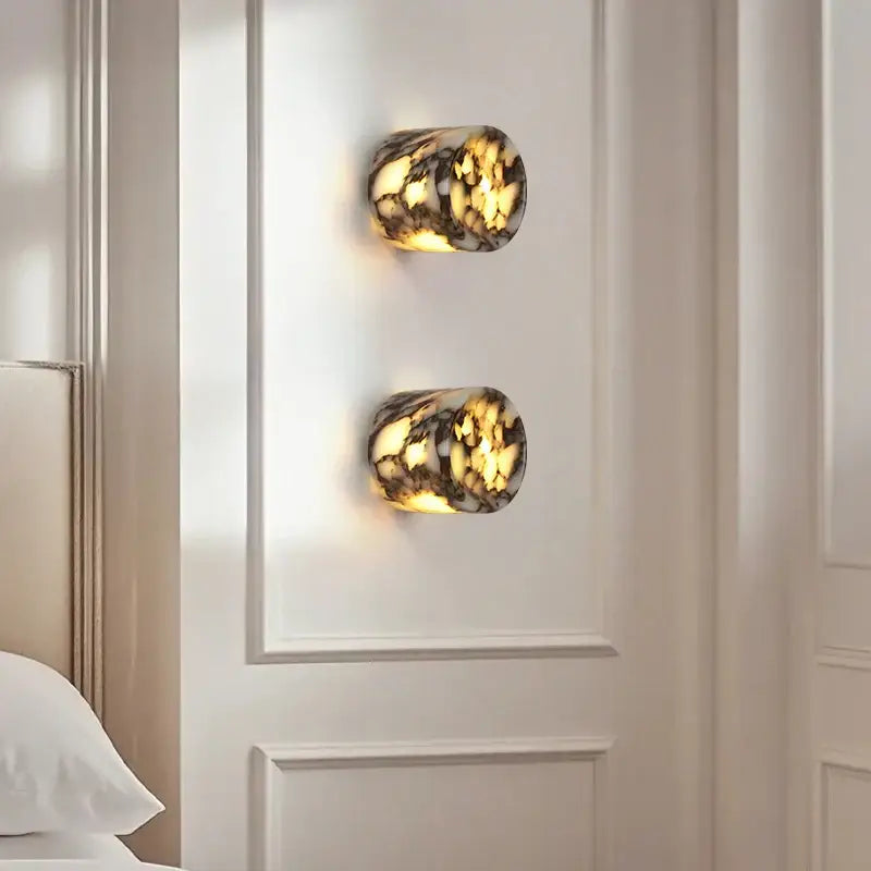 Modern wabi sabi black and cream resin led wall lamp with amber marbled glass emits soft golden light on white wall