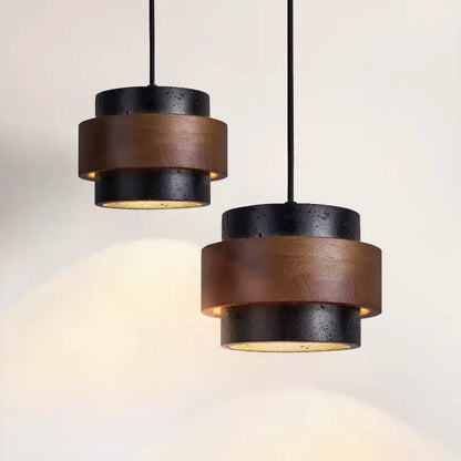 Modern wabi sabi tiered stone pendant light with stacked black and bronze cylindrical shades for dining room use with led bulb