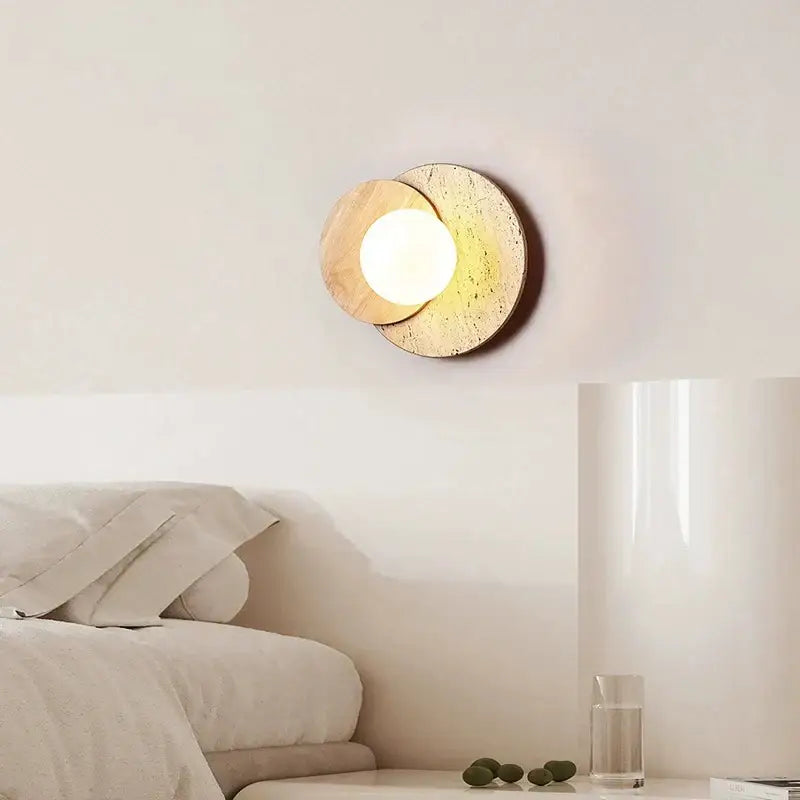 Modern walnut and cork led wall lamp with two overlapping circular discs emitting warm light for bedroom use
