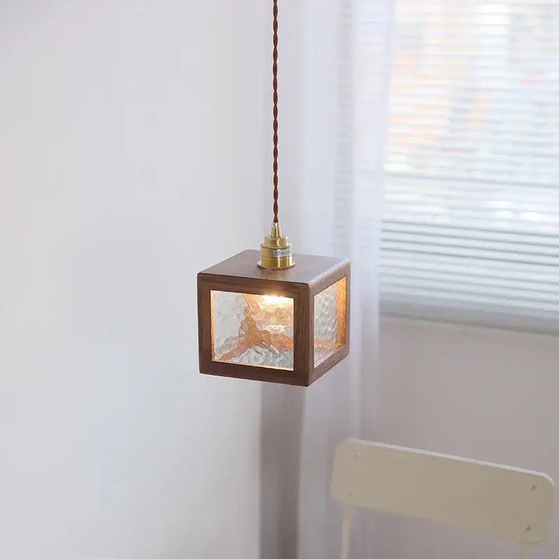 Modern walnut wood and clear glass cube pendant light with a warm-toned dark wood frame for dining room use