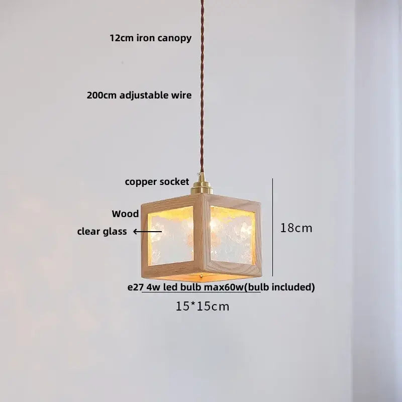 A warm-lit 18cm cube pendant light with walnut wood frame and clear glass panels for dining room use