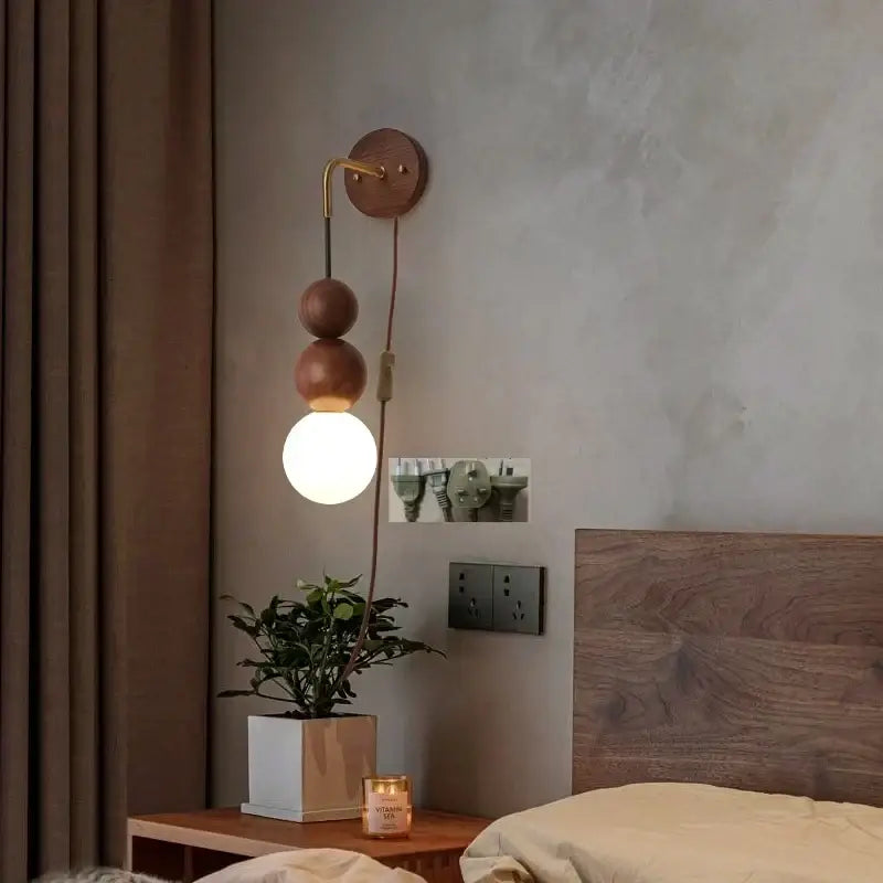 Modern walnut wood and white glass wall light with brass curved arm and stacked wooden spheres for adjustable led wall decorbites