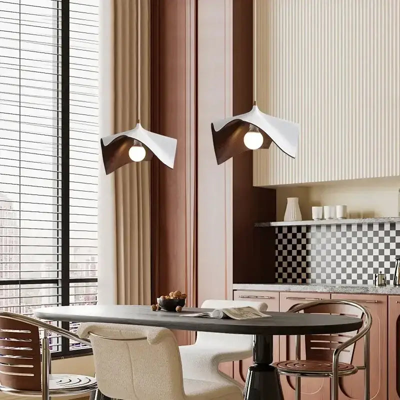 Modern wave black and bronze chandelier pendant light with sculptural white and bronze wing-like design above dining table