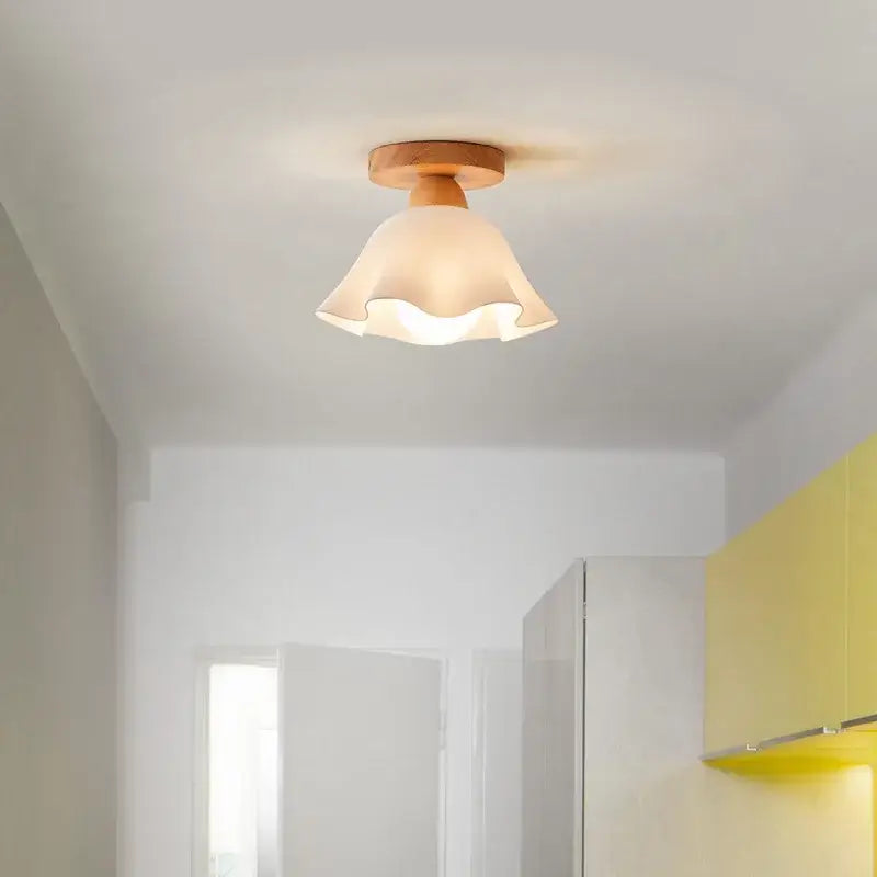 A warm-toned modern wavy frosted glass ceiling lamp with decorbites led wood base and ruffled shade for bedroom
