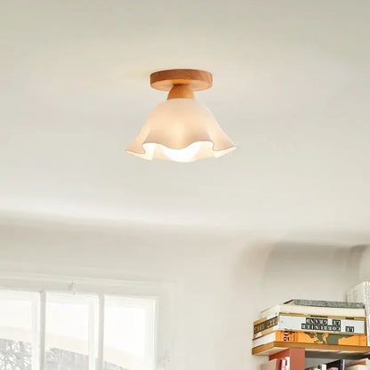 A warm-toned modern wavy frosted glass ceiling lamp with scalloped edges and a wooden decorbites led wood base
