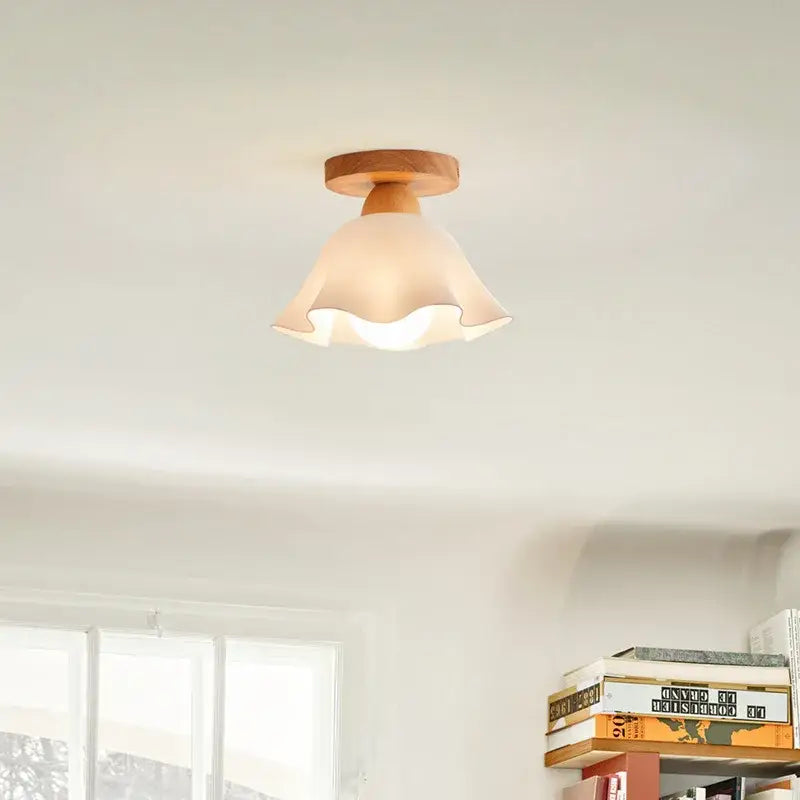 A warm-toned modern wavy frosted glass ceiling lamp with scalloped edges and a wooden decorbites led wood base