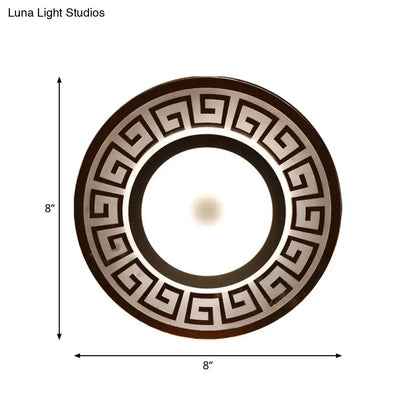 Modern white acrylic wall lamp with circular dark brown and metallic silver greek key border for bedroom use