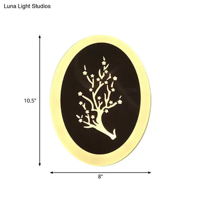 Gold-framed oval wall art with a delicate white tree on dark background paired with modern white acrylic cloud led wall lamp