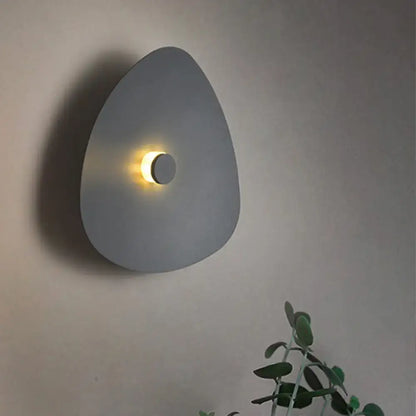 Modern gray teardrop-shaped flaky sconce light with warm circular light in white acrylic bedroom wall fixture