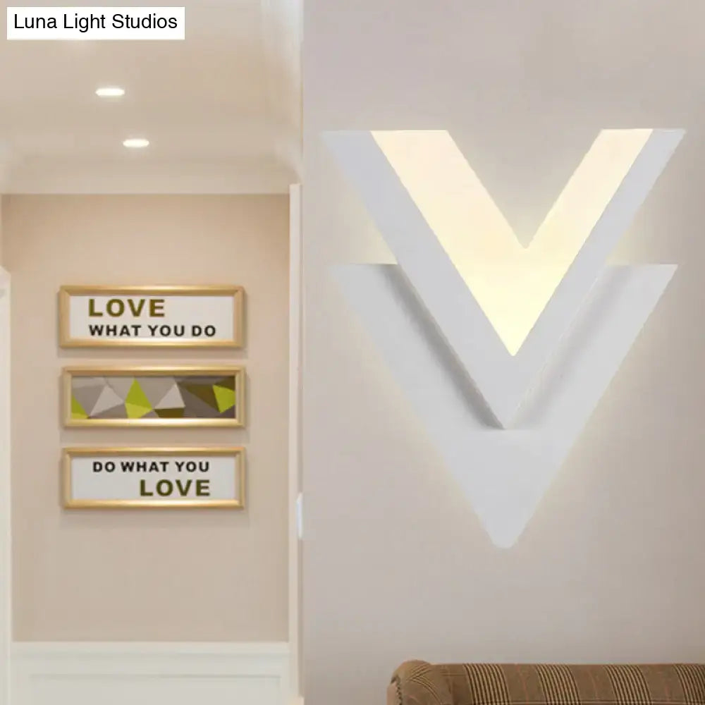 Modern white acrylic led sconce light with v-shaped layered geometric design emitting warm white glow for bedroom