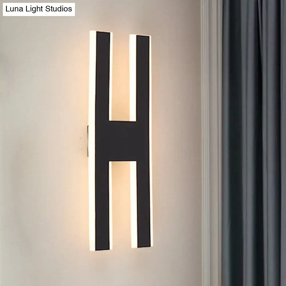Modern black h-shaped wall lamp with illuminated edges casting warm glow for bedroom led sconce 110v-120v use