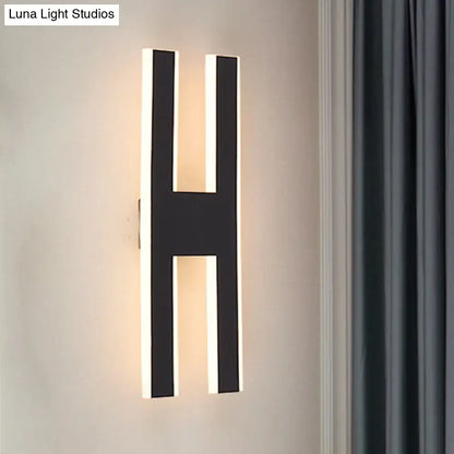 Modern black h-shaped wall lamp with illuminated edges casting warm glow for bedroom led sconce 110v-120v use