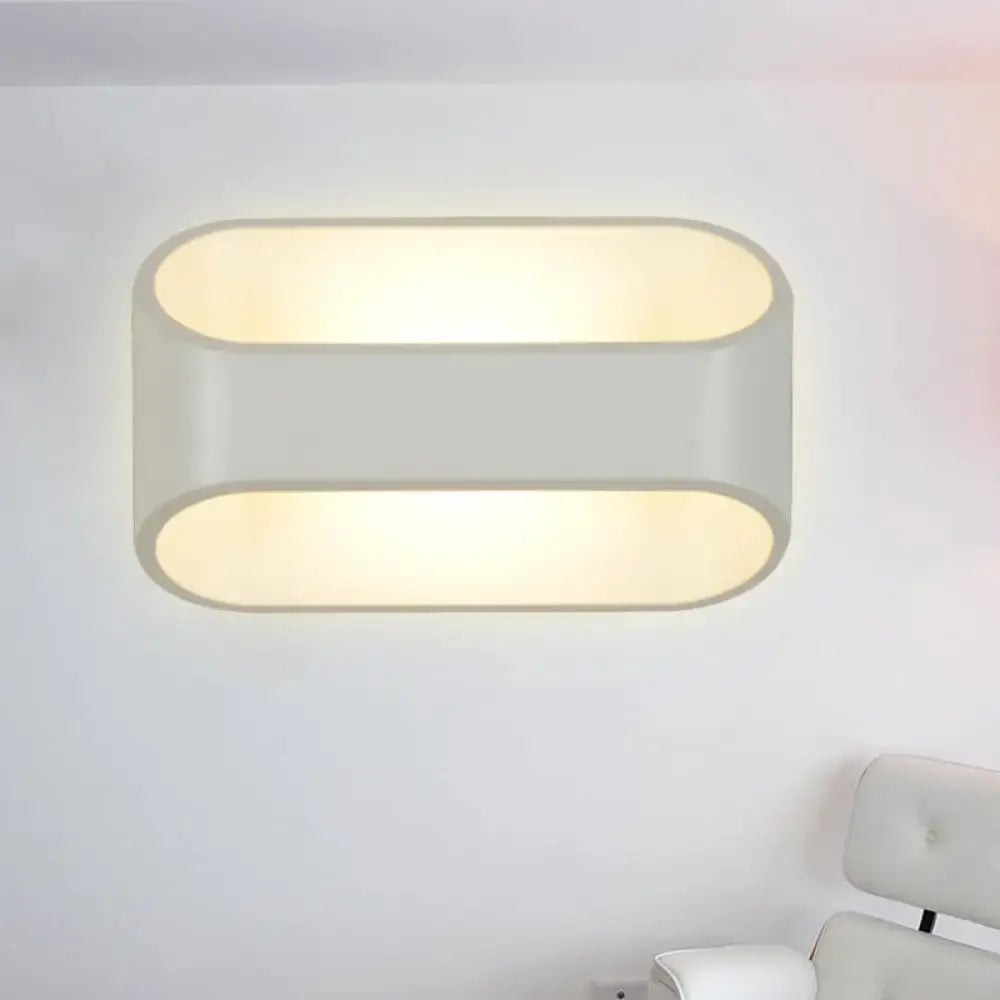 Modern white aluminum led wall sconce with two horizontal oval panels and frosted glass diffusers emitting warm glow