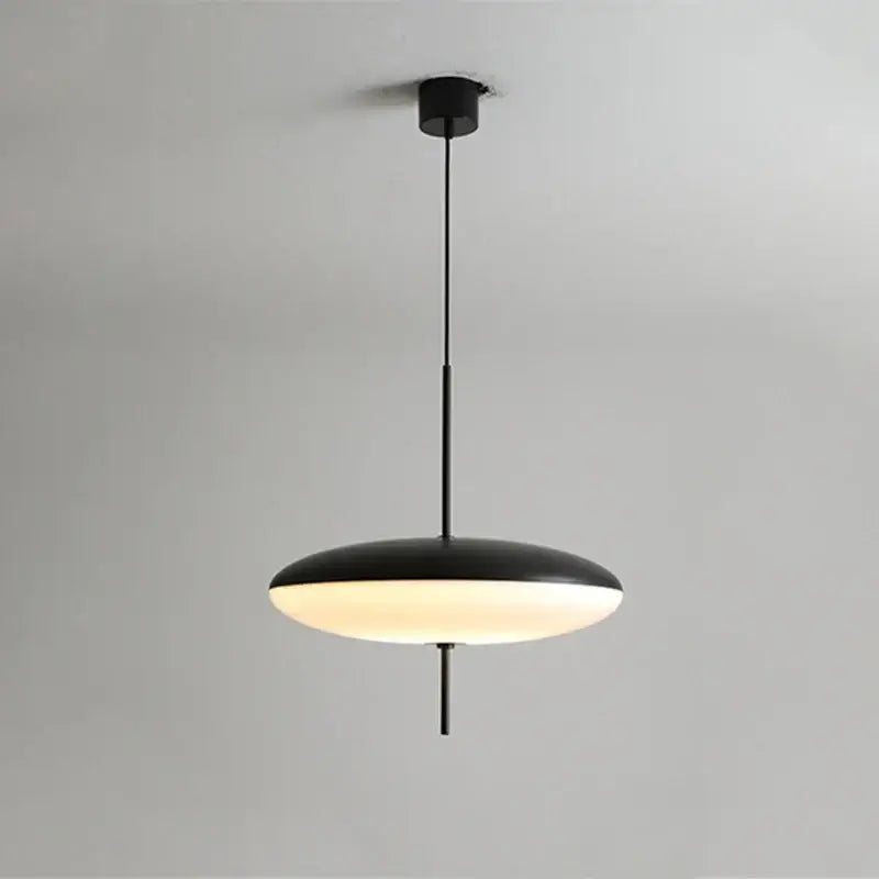 Black acrylic pendant light with sleek disc-shaped shade and warm glow for modern white and black kitchen decorbites decor