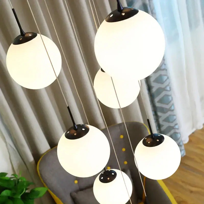 Modern white and black cream glass ball chandelier with frosted glass globes for staircase lighting by decorbites cream glass