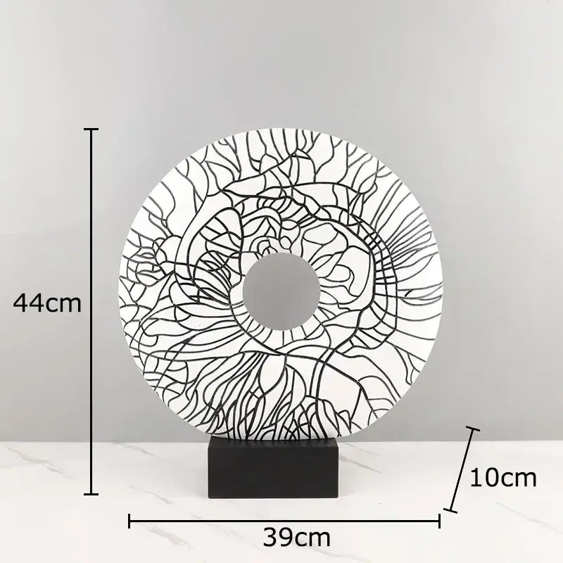 Modern white and black floral decorbites circle ornament with intricate line art on a black rectangular base