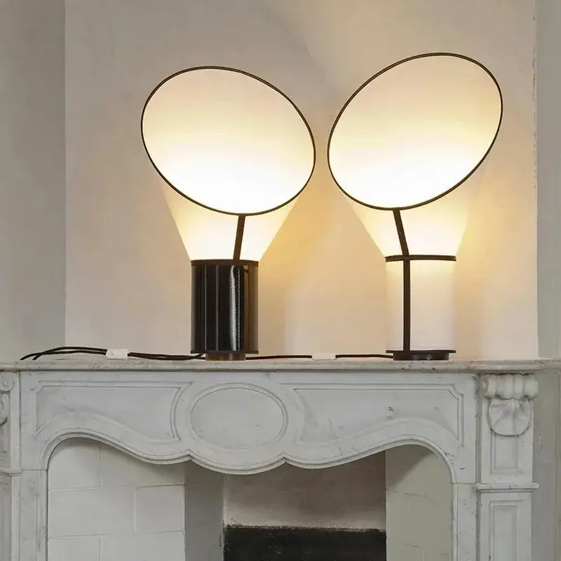Two modern white and black horn floor lamps with circular glowing shades and sleek cylindrical bases for bedroom decorbites decor