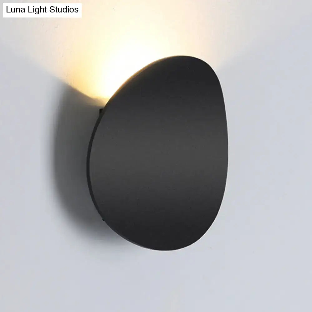 Modern style black matte wall sconce with oval shape and warm focused led light for bedroom use